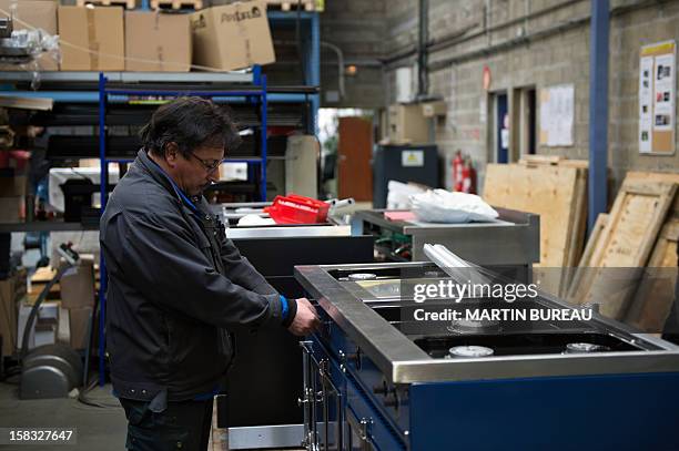 An employee of French cooker maker "La Cornue" works in the factory on December 13 in Saint-Ouen-l'Aumone, north of Paris. AFP PHOTO / MARTIN BUREAU