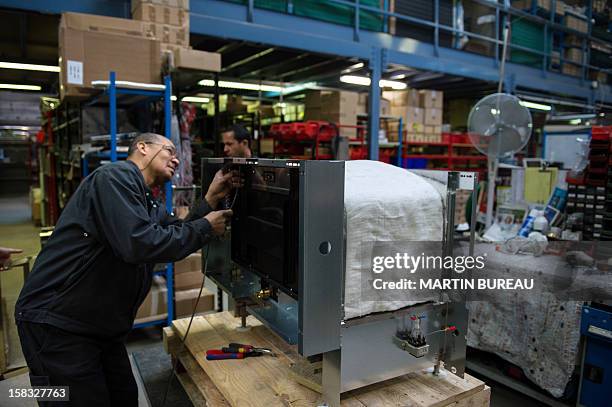 An employee of French cooker maker "La Cornue" works in the factory on December 13 in Saint-Ouen-l'Aumone, north of Paris. AFP PHOTO / MARTIN BUREAU