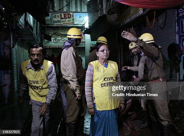 Civil Defence members assist Fire fighters to douse a fire at a godown in Bhagirath Palace, an electrical market of Chandni Chowk area, on December...