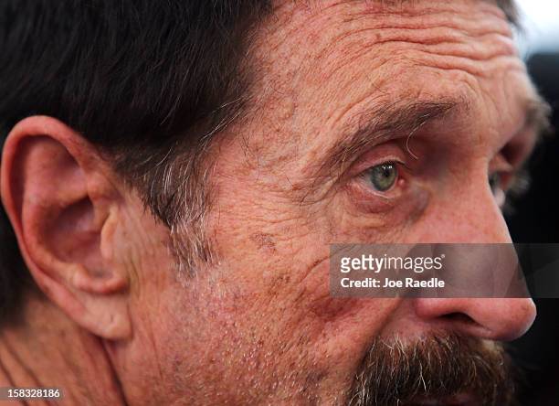 John McAfee speaks with reporters outside of the Beacon Hotel where he is staying after arriving last night from Guatemala on December 13, 2012 in...