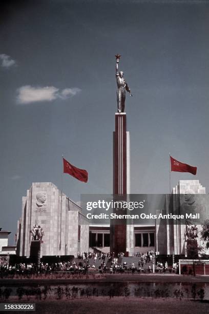 View of the U.S.S.R. Building designed by Boris Iofan showing profiles of Lenin and Stalin, the statue of 'Joe the Worker', Soviet flags and...