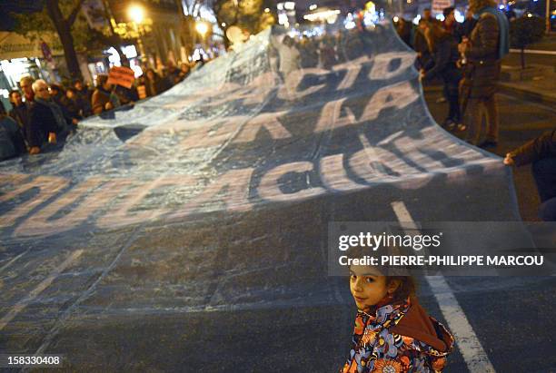 Young girl stands in front of a giant banner reading "Agreement for the education" during a protest against government's austerity reforms and cuts...