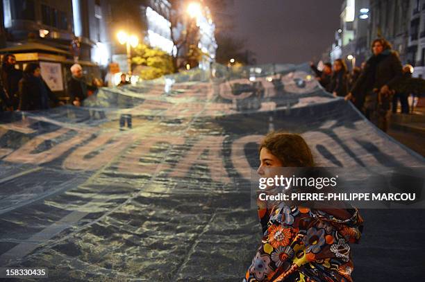 Young girl stands in front of a giant banner reading "Agreement for the education" during a protest against government's austerity reforms and cuts...