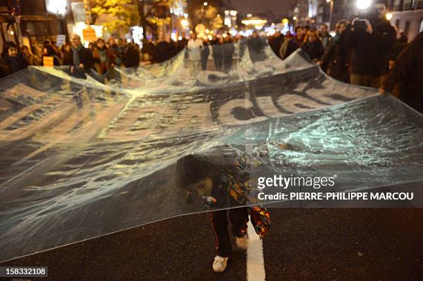 Young girl walks under a giant banner reading "Agreement for the education" during a protest against government's austerity reforms and cuts in...