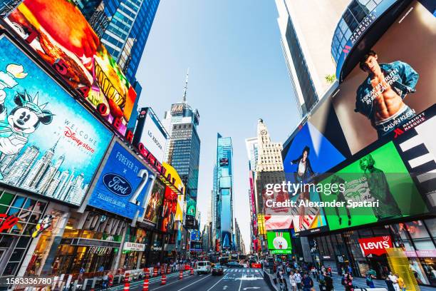 wide angle shot if times square with bright led displays on a sunny day, new york city, usa - times square store stock pictures, royalty-free photos & images