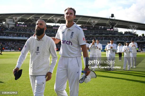 Stuart Broad of England interacts with team mate Moeen Ali as they make their way off following the end of the match and the end of their career...