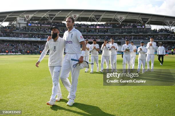 Stuart Broad of England interacts with team mate Moeen Ali as they make their way off following the end of the match and the end of their career...