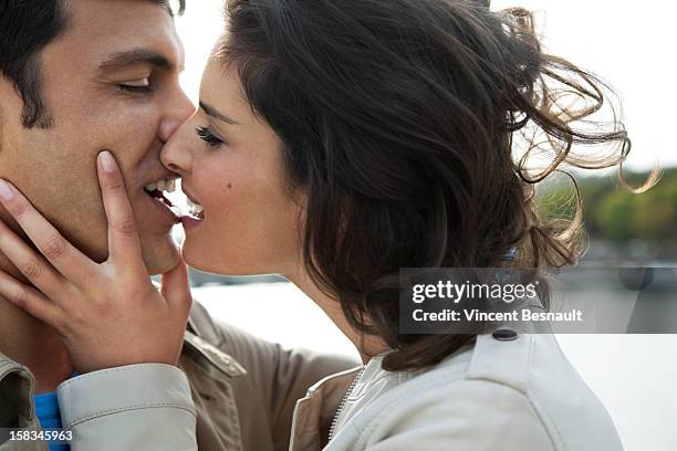 a young couple embracing on a bridge in paris - falling in love stock pictures, royalty-free photos & images