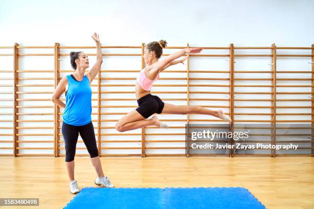 gymnast girl training rhythmic gymnastics with her coach - gimnasia artística fotografías e imágenes de stock