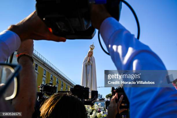 Visual journalists surround the Pilgrim Image of Our Lady of Fatima sitting atop of a truck and escorted Boy Scouts after having sailed the Tagus...