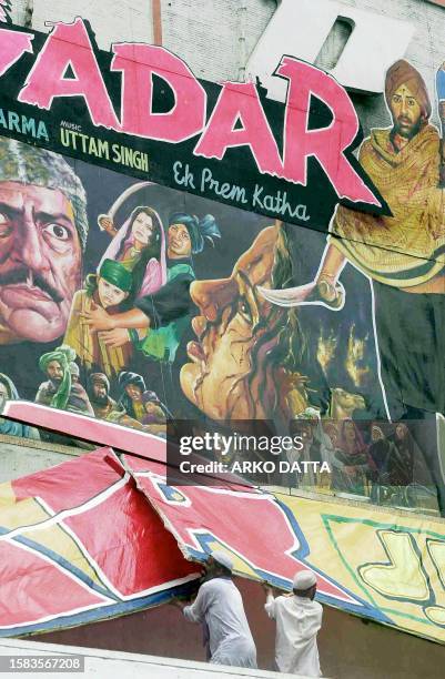 Activists belonging to the Muslim fundamentalist organization Ali Sena tear down a movie billboard for the film "Gadar" outside a cinema hall in New...