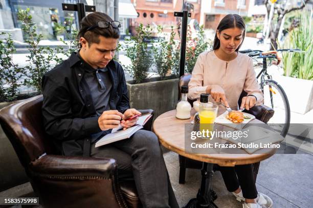 coworkers working and eating a sidewalk cafe - colombia business breakfast meeting stock pictures, royalty-free photos & images