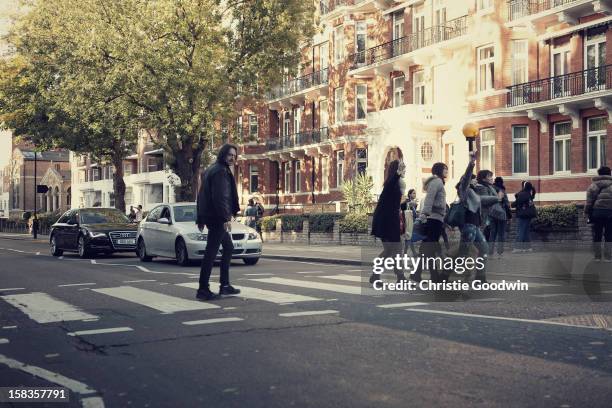 Tourists walk across the zebra crossing outside Abbey Road recording Studios on October 19, 2012 in London, United Kingdom.
