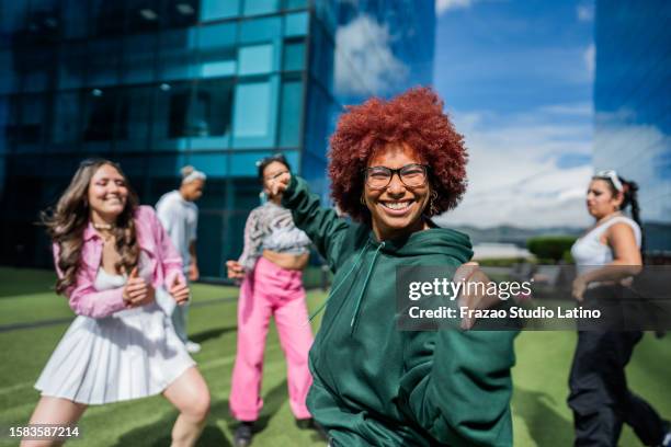 young woman dancing with her friends outdoors - colombia dance stock pictures, royalty-free photos & images