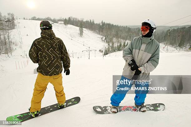 Snowboarders prepare to go down from the top of Zagarkalns' main slope in Cesis, Latvia on December 5, 2012. In the flat Baltic nation of Latvia,...