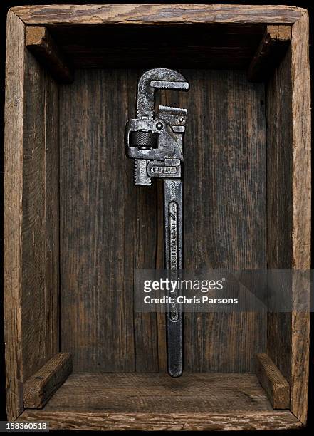 monkey wrench floating in antique wooden box. - adjustable wrench stock-fotos und bilder