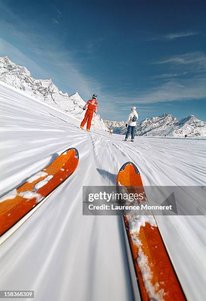 close-up of skis, following skiiers on a ski slope - esquí fotografías e imágenes de stock