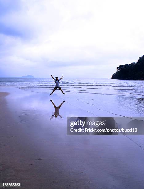 pulando na praia - pulando fotografías e imágenes de stock