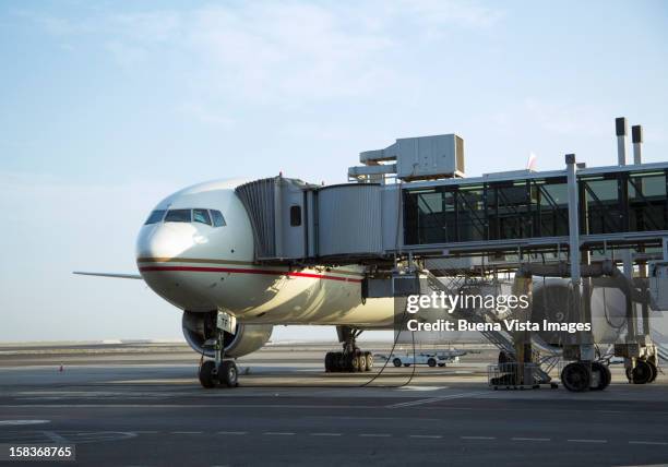 airplane at a drawbridge in the airport - abu dhabi airport stockfoto's en -beelden