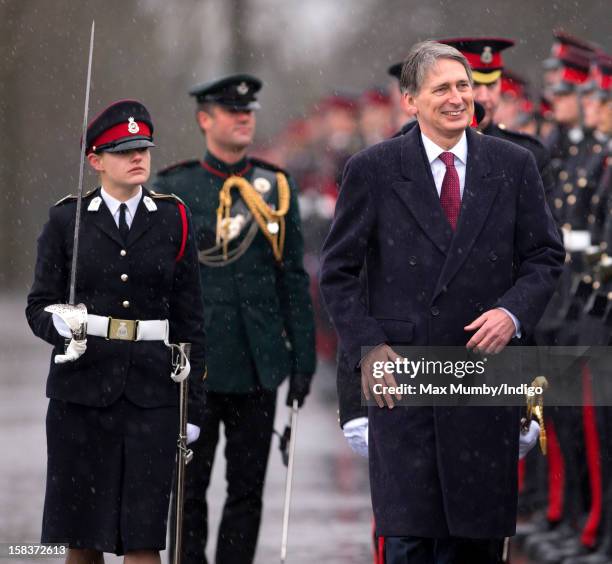 Senior Under Officer Sarah Hunter-Choat accompanies Secretary of State for Defence Philip Hammond as he inspects the Officer Cadets whilst...