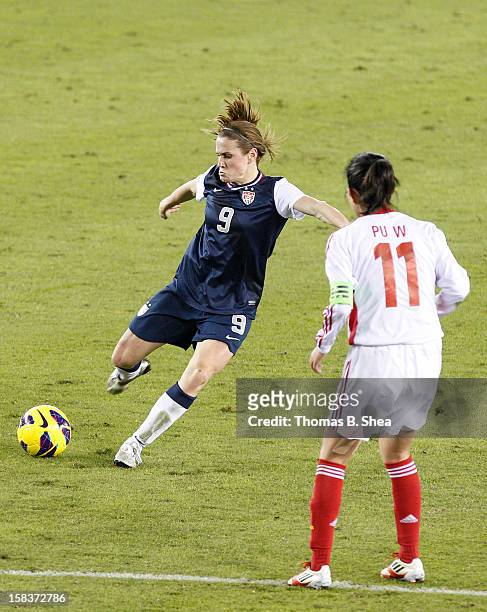 Heather O'Reilly of the U.S. Women's National Team strikes the ball while Pu Wei midfielder of the China Women's National Team defends in an...