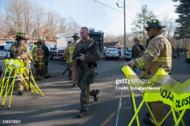 Connecticut State Police walk near the scene of an elementary school shooting on December 14, 2012 in Newtown, Connecticut. According to reports,...
