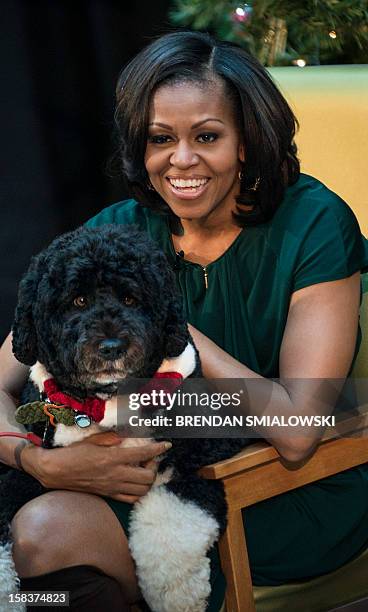 First lady Michelle Obama holds the first family's dog, Bo, before reading at Children's National Medical Center December 14, 2012 in Washington, DC....