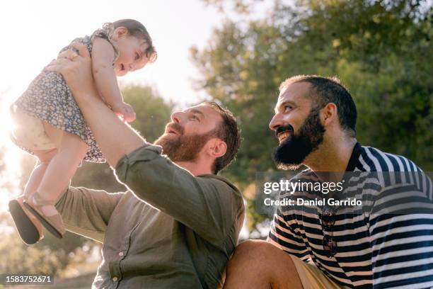 happy dads thanks to surrogacy, two dads and their cherished daughter, a dream come true. - surrogato foto e immagini stock