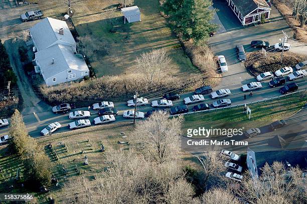 Police cars and other vehicles fill a road near the scene of a mass school shooting at Sandy Hook Elementary School on December 14, 2012 in Newtown,...