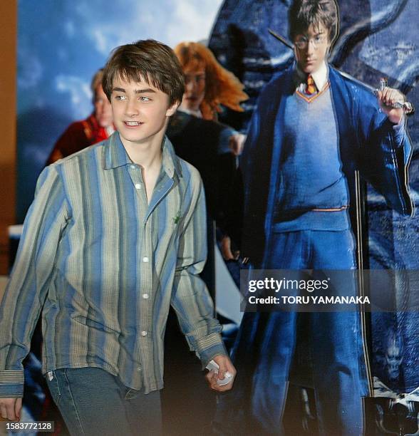 British actor Daniel Radcliffe walks past poster of their new movie "Harry Potter and the Chamber of Secrets" prior to a press conference in Tokyo,...