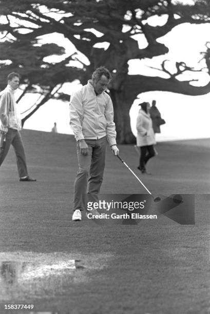During the Bing Crosby National Pro-Amateur golf tournament, American actor Jack Lemmon reacts to his shot from the fairway on the course near the...
