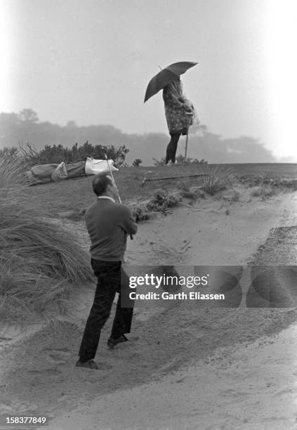 During the Bing Crosby National Pro-Amateur golf tournament, golfer Wheeler Farish Jr shoots out of a sand trap on the course at Cypress Point,...