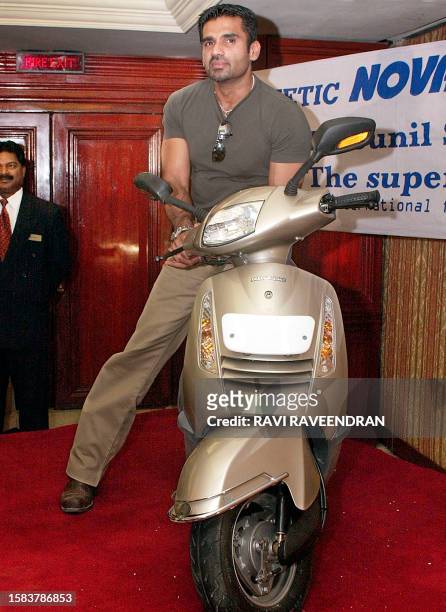 "Bollywood" superstar Sunil Shetty poses with Kinetic's new scooter, the "Nova", at its launch in New Delhi 22 June 2002. Kinetic Motor company...