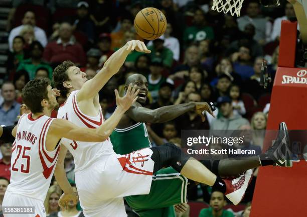 Chandler Parsons and Omer Asik of the Houston Rockets battle for a rebound with Kevin Garnett of the Boston Celtics at the Toyota Center on December...