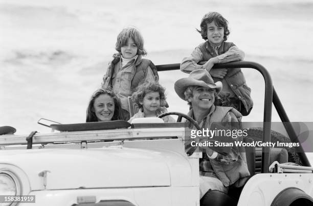 American fashion designer Ralph Lauren and his wife, therapist Ricky Lauren, drive in a jeep on the beach with their children, David, Andrew, &...