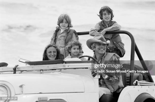 American fashion designer Ralph Lauren and his wife, therapist Ricky Lauren, drive in a jeep on the beach with their children, David, Andrew, &...