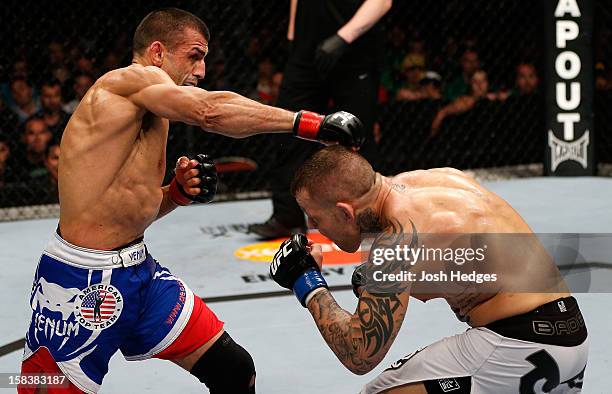 George Sotiropoulos punches Ross Pearson during their lightweight fight at the UFC on FX event on December 15, 2012 at Gold Coast Convention and...