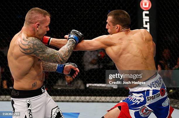 George Sotiropoulos punches Ross Pearson during their lightweight fight at the UFC on FX event on December 15, 2012 at Gold Coast Convention and...