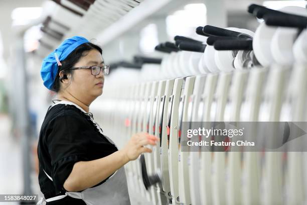 Woman labors at polyester fiber manufacturing in Yushan county in central China's Jiangxi province.