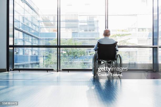 senior hombre en silla de ruedas - edificio residencial fotografías e imágenes de stock
