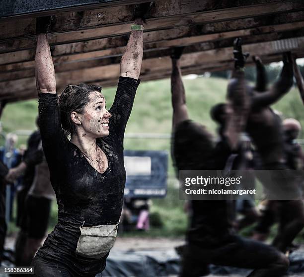 female athlete competing in an obstacle course - rivaliteit stockfoto's en -beelden