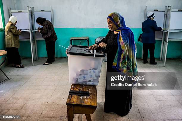 An Egyptian woman casts her vote during a referendum on the new Egyptian constitution at a polling station on December 15, 2012 in Cairo, Egypt....