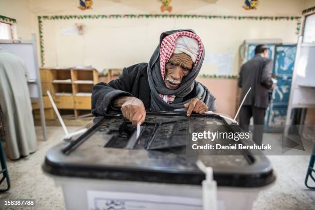 An Egyptian man casts his vote during a referendum on the new Egyptian constitution at a polling station on December 15, 2012 in Cairo, Egypt....