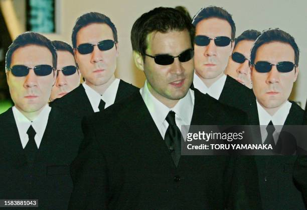 Man appears as he wears panels showing life-size pictures of Australian actor Hugo Weaving before a premiere of new movie "Matrix Reloaded" in Tokyo...