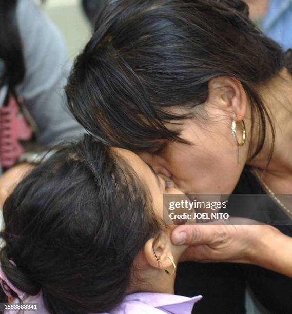 Filipino worker living in Lebanon kisses her daughter upon her return to Manila's airport, 29 July 2006. There are an esimated 30,000 Filipino...