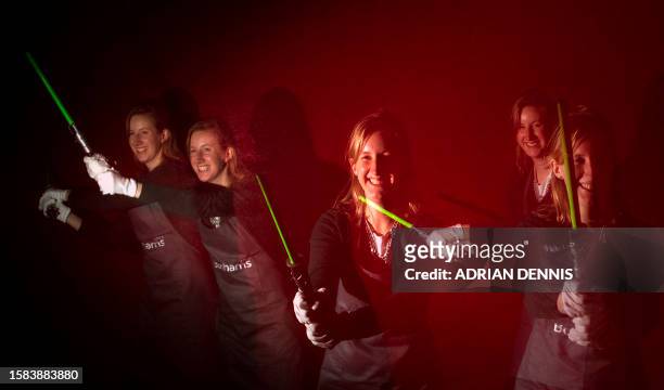 In a multiple exposure picture Katherine Boyle, a press officer at Bonhams auction house, waves a light saber used by Ewan McGregor in the film Star...
