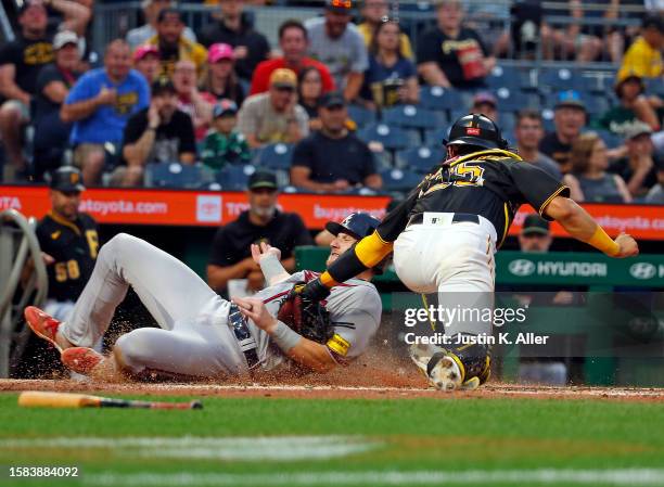 Sean Murphy of the Atlanta Braves scores against catcher Endy Rodriguez of the Pittsburgh Pirates on a fielding error in the fourth inning during the...