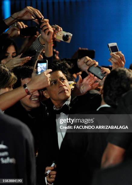 Indian actor Shah Rukh Khan poses with fans at the UK premiere of Bollywood science fiction film Ra One at the O2 Arena on October 25, 2011. AFP...