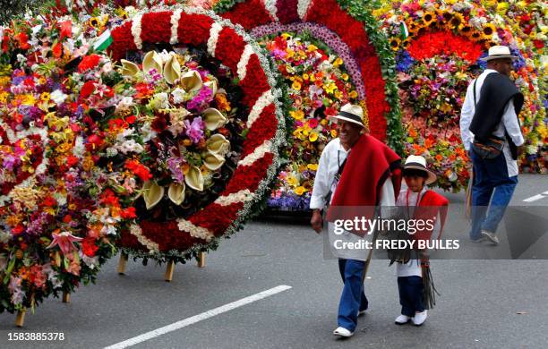 Farmers walk by flower arrangements known as "silletas" before the traditional Silleteros parade, held as part of the Flower Festival, in Medellin,...