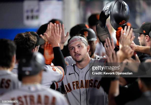 Patrick Bailey of the San Francisco Giants is congratulated in the dugout after scoring on a base hit by Mark Mathias during the ninth inning against...